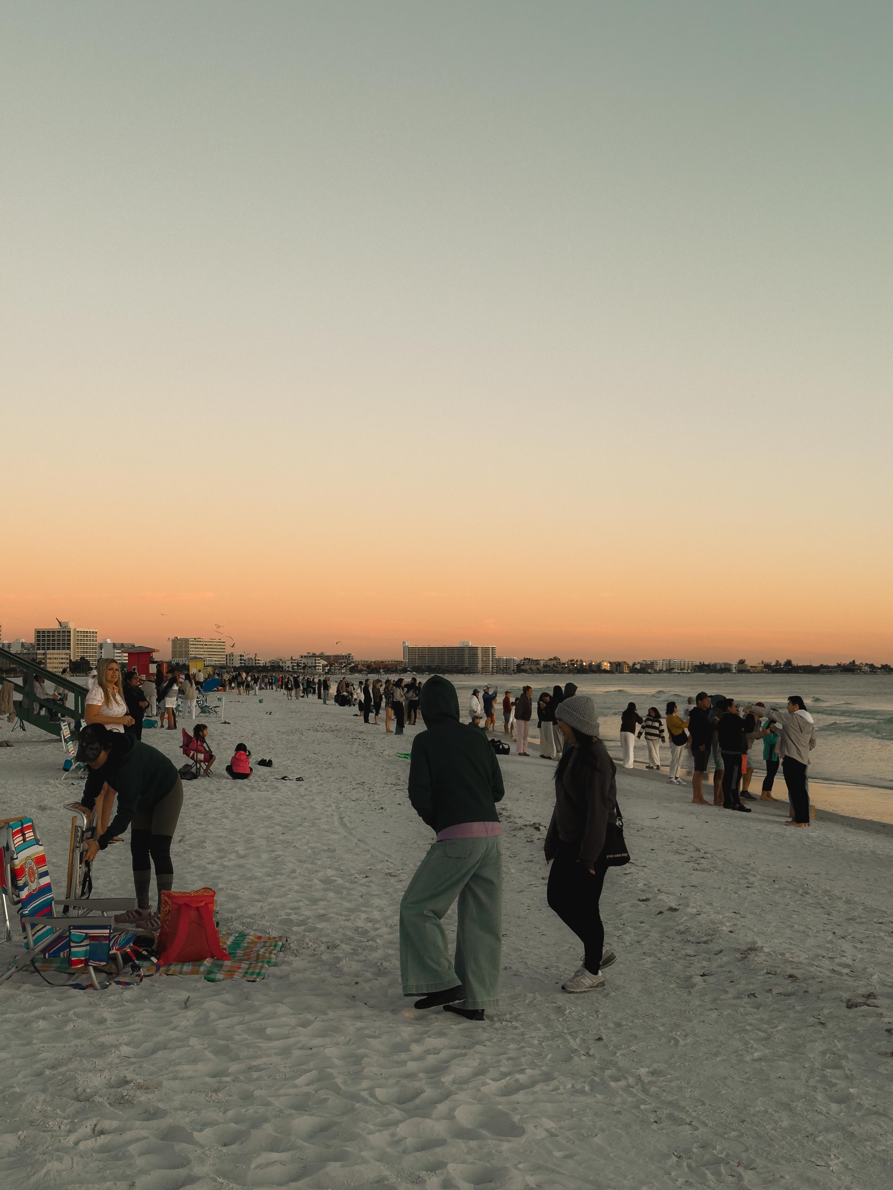 People walking along a beach at dusk