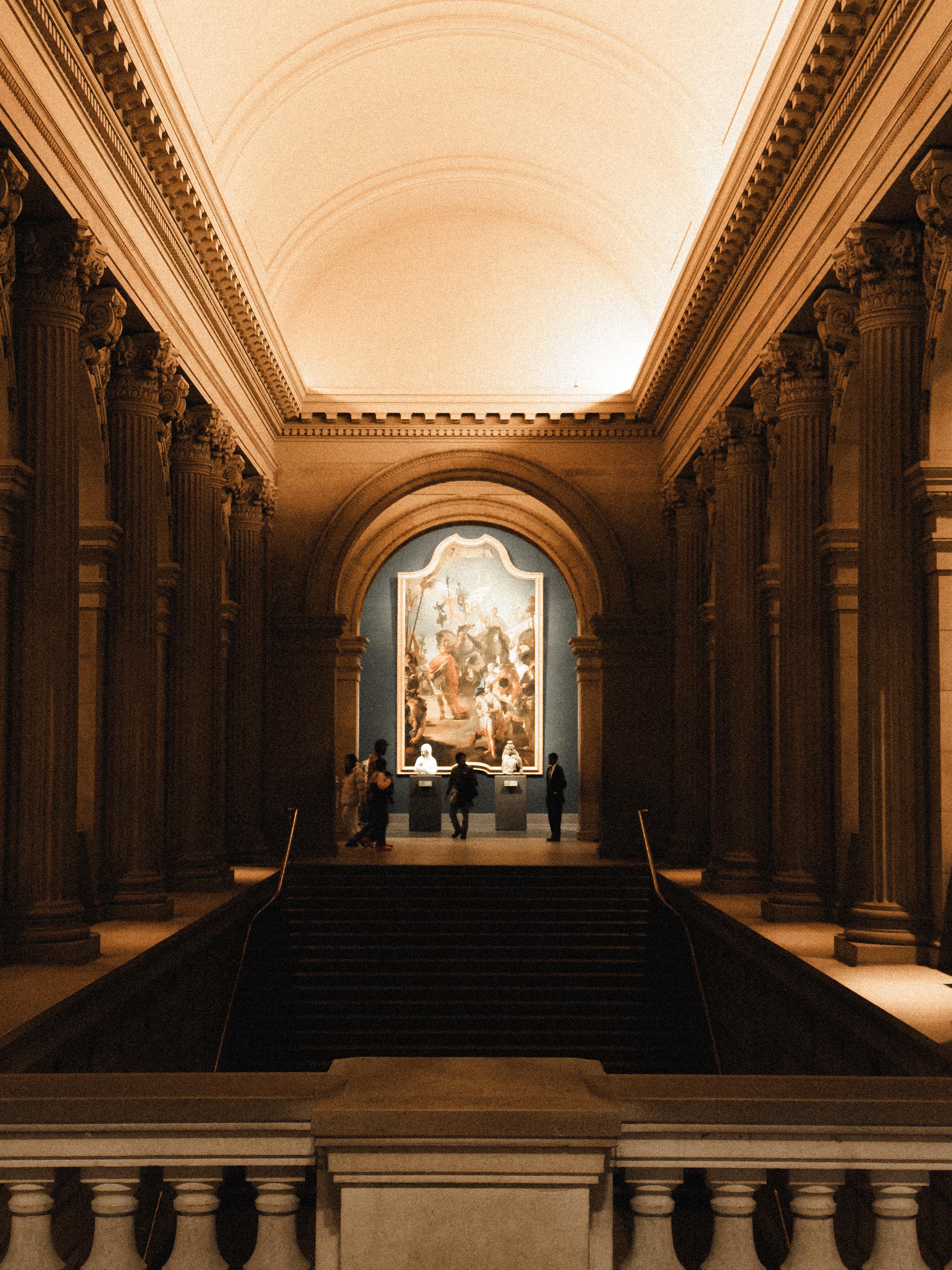 Visitors beneath the vaulted ceiling of a museum