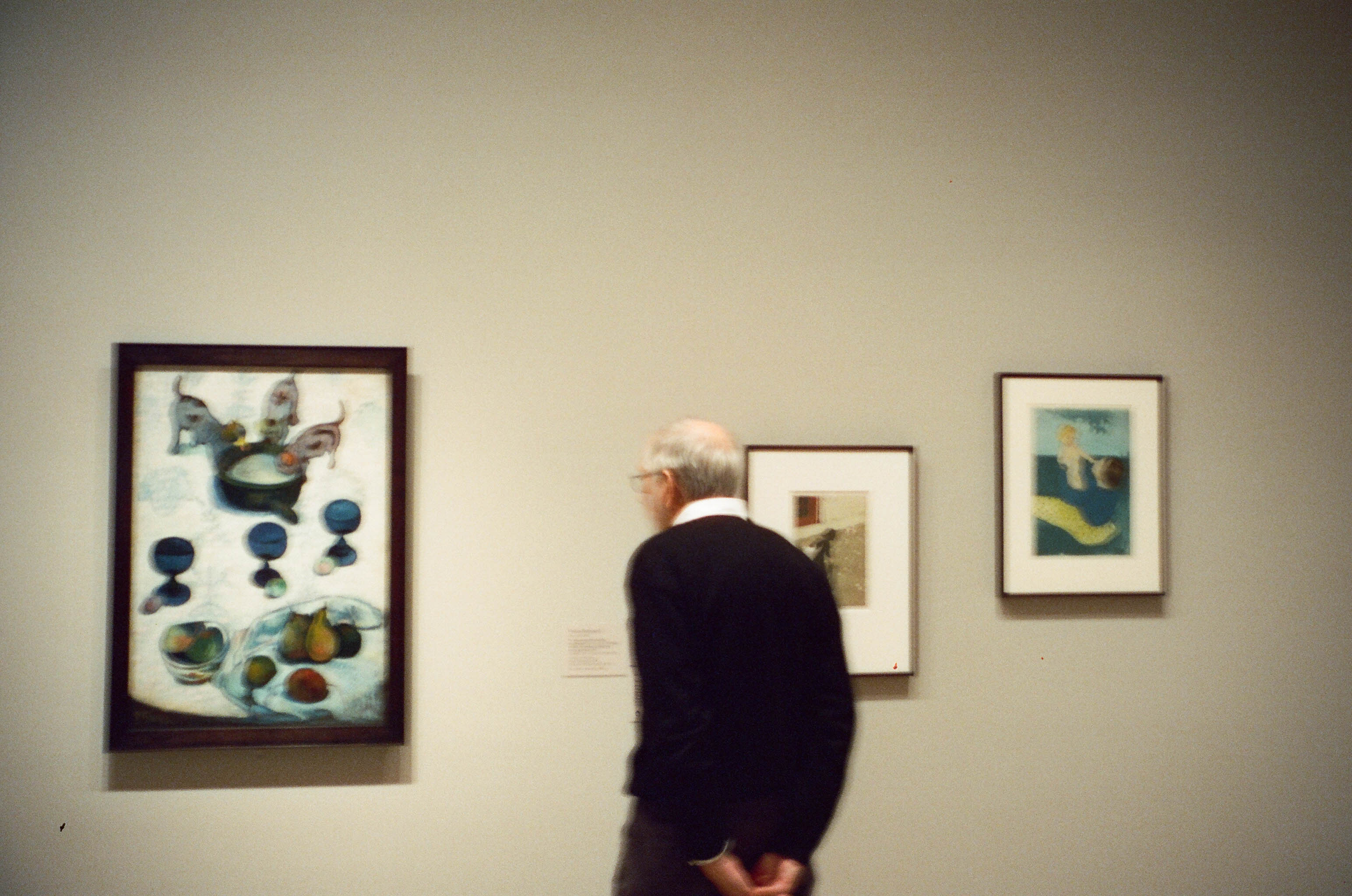 A visitor studying framed artworks